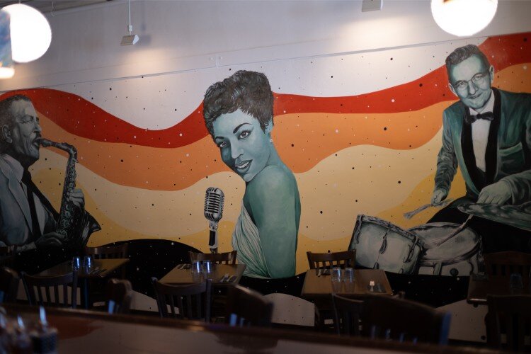 A mural hand painted by Hi Hat employee Cheyenne Shuttlesworth adorns the wall of the new eatery.